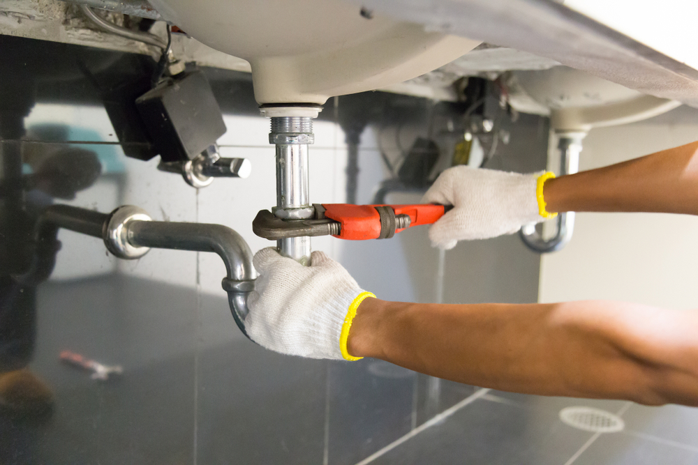 A plumbing expert perfoming a repair on a sink P-trap.
