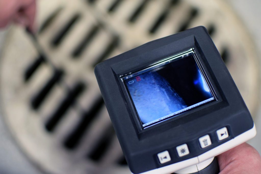A screen showing us the video feed from a plumbing snake camera.