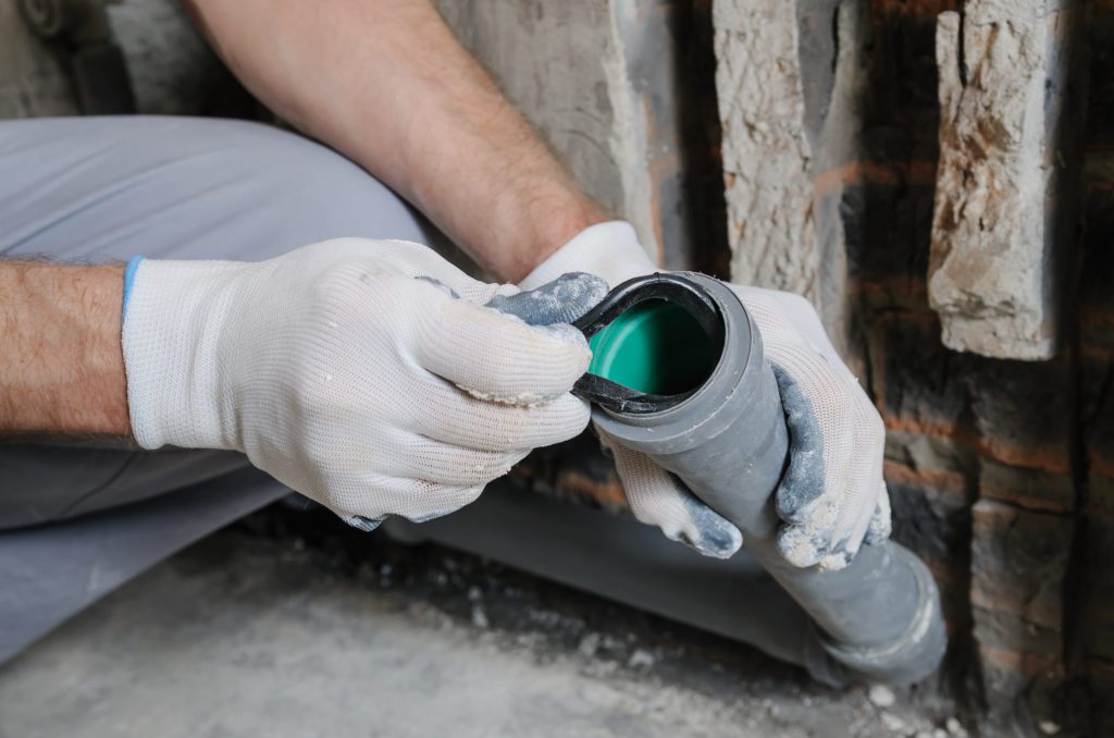 A plumber in the middle of a plumbing service.