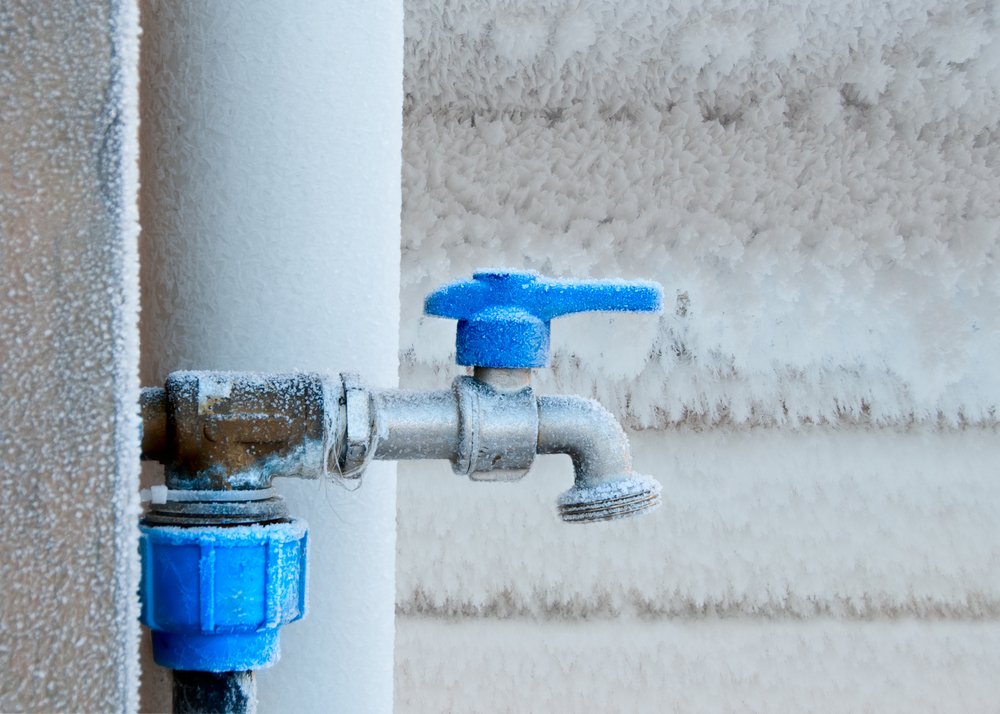 Outdoor faucet with blue handle covered in frost in Toronto