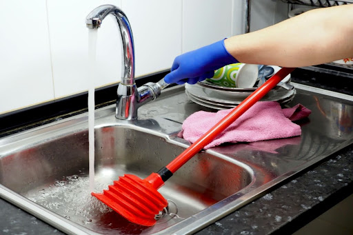 Homeowner attempting to plunge kitchen sink